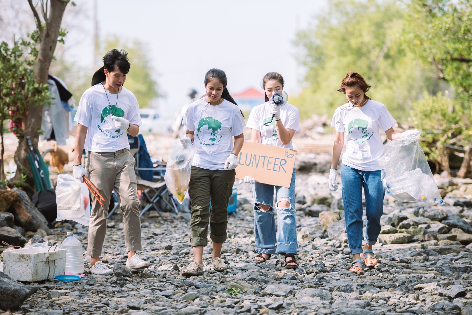 Volunteers collecting litter along a rocky shoreline